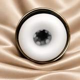 A close-up studio shot of a white circular ring-shaped product with a gold-toned rim, placed on draped champagne satin fabric.